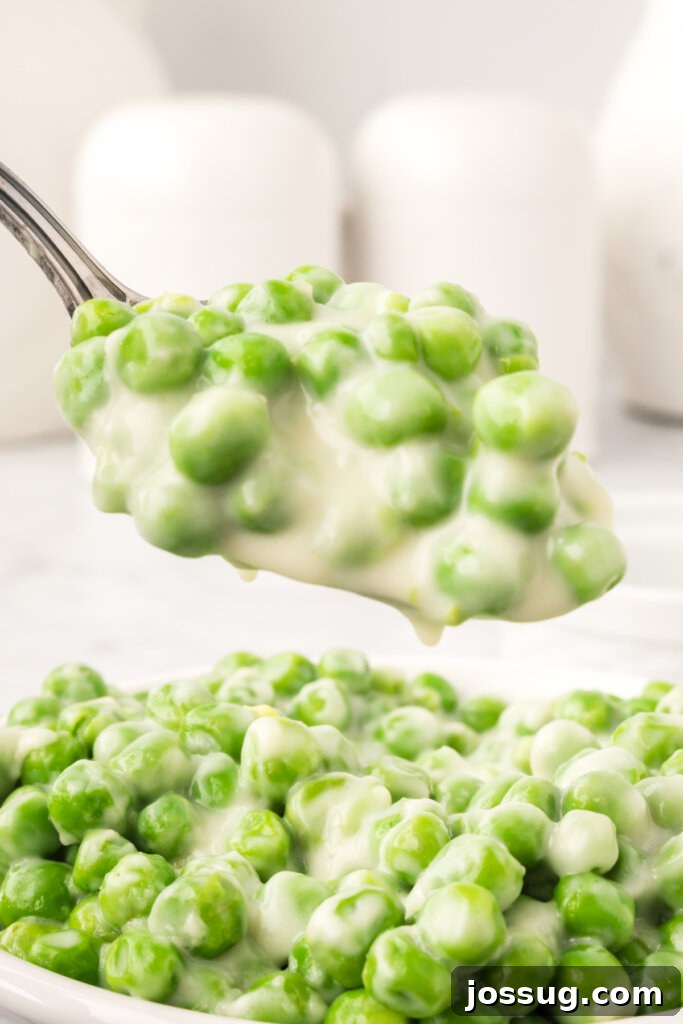 Velvet Peas 3 Creamed peas being scooped onto a spoon from a pan, showing off their rich sauce