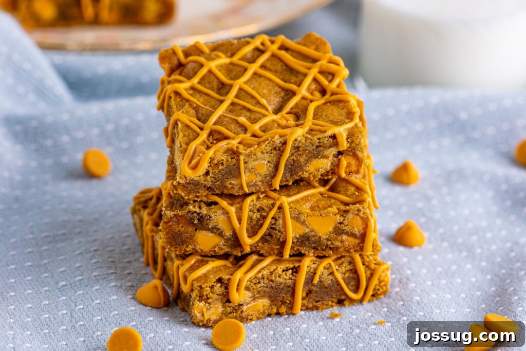 three butterscotch blondies stacked with a beautiful golden-brown crust and melted chips