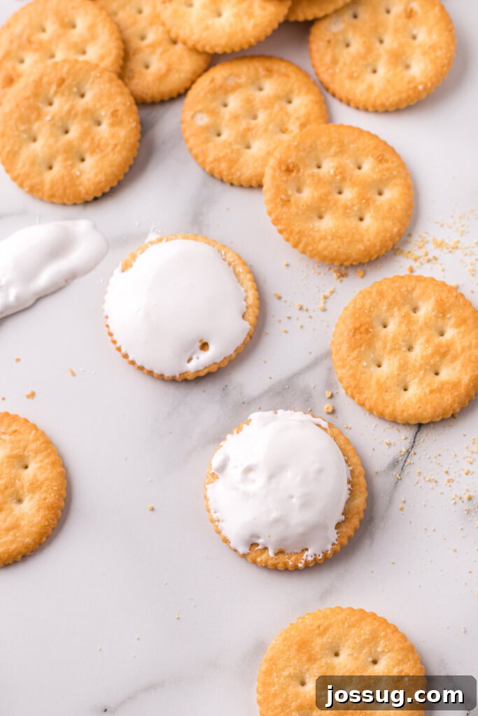 Gooey Smores Cracker Bites 4 Spreading marshmallow cream onto a Ritz cracker base.