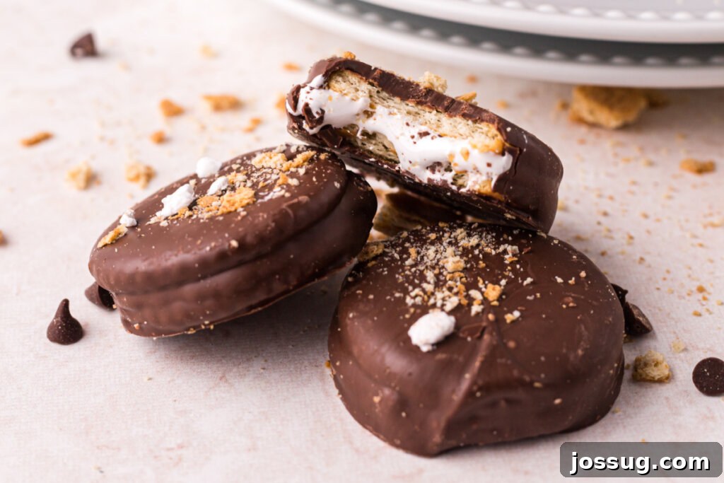 Gooey Smores Cracker Bites 9 Three S'mores Cracker Cookies stacked on top of each other, showing the marshmallow filling and chocolate coating.