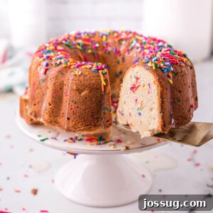 Sliced Funfetti Pound Cake displayed on a cake stand, revealing its colorful interior.