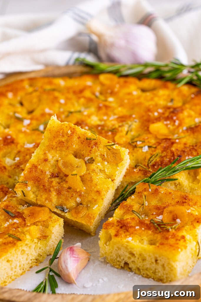 closeup of piece of focaccia bread with the loaf