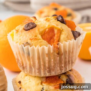Closeup of a single moist orange muffin, showcasing its tender crumb and golden crust.
