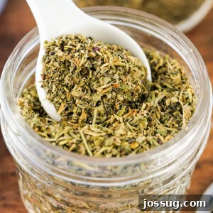 teaspoon scooping italian seasoning from glass jar
