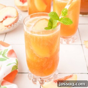A glass filled with beautifully iced peach tea, ready to be enjoyed.