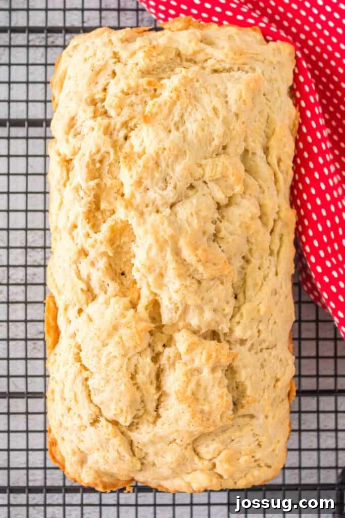 No-Knead Beer Bread 4 A freshly baked loaf of Beer Quick Bread cooling on a wire rack, viewed from above, showcasing its golden crust.