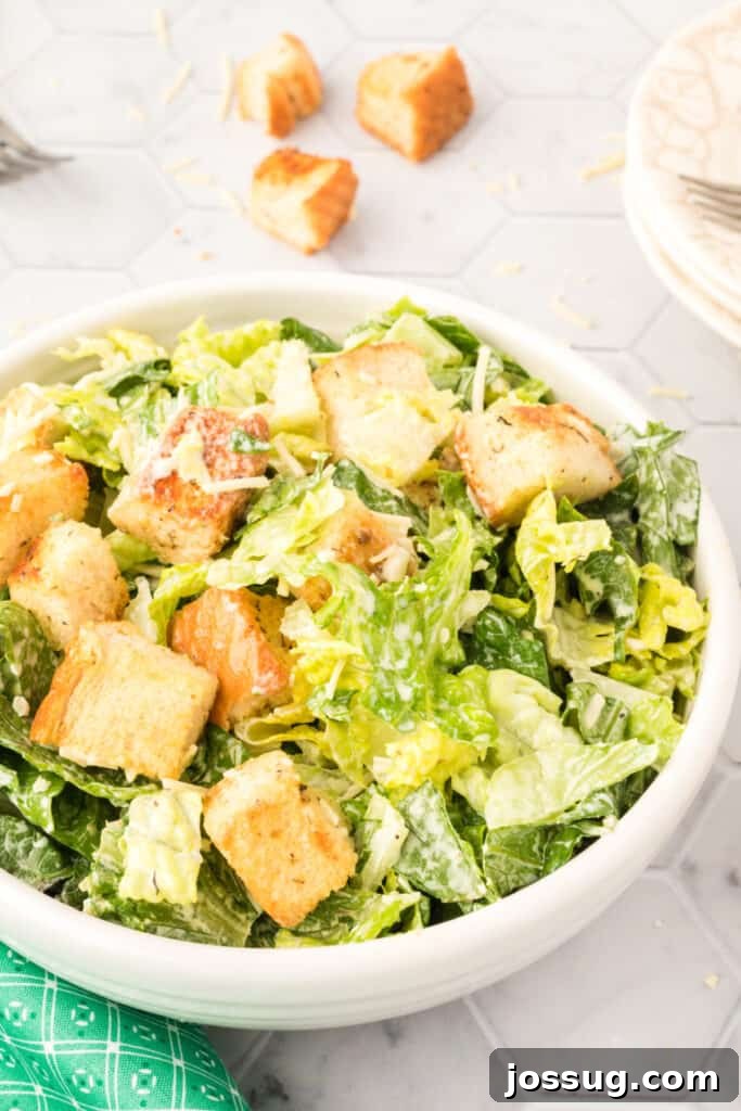 The Emperor's Salad 3 closeup of caesar salad in a white bowl on a wooden table, emphasizing the fresh ingredients