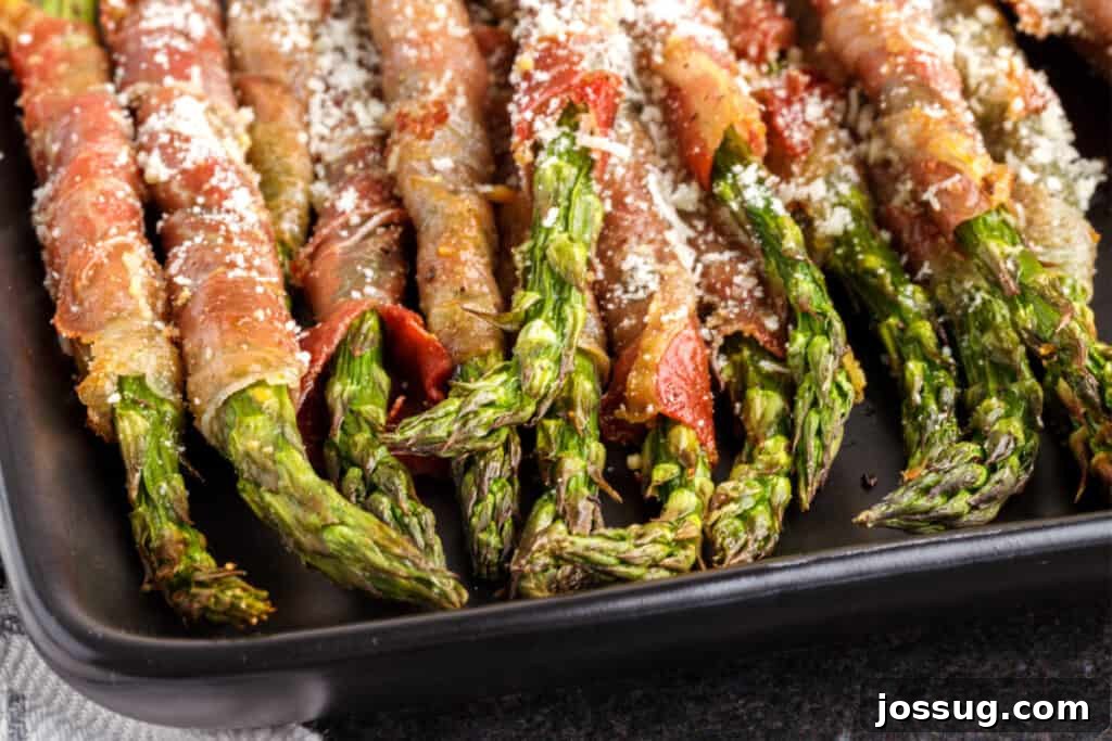 air fryer prosciutto wrapped asparagus on black plate