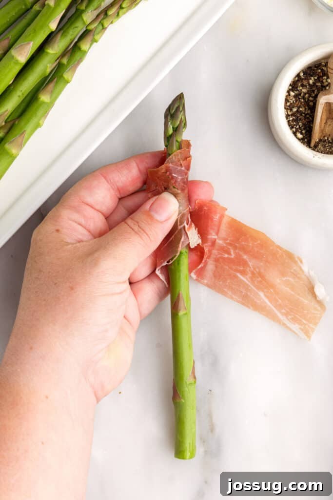 Wash and dry asparagus. Break or cut woody ends off asparagus. Cut prosciutto in half, lengthwise. Wrap prosciutto in a spiral around asparagus stalk.
