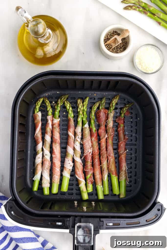 Place prosciutto wrapped asparagus in the air fryer basket. 