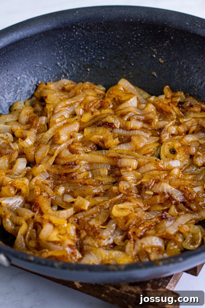 Coke-Kissed Caramelized Onions 2 Caramelized onions simmering in a pan with Coca-Cola