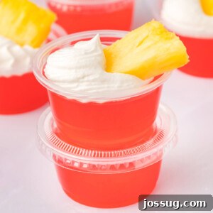 Two rum punch jello shots stacked, ready to be enjoyed