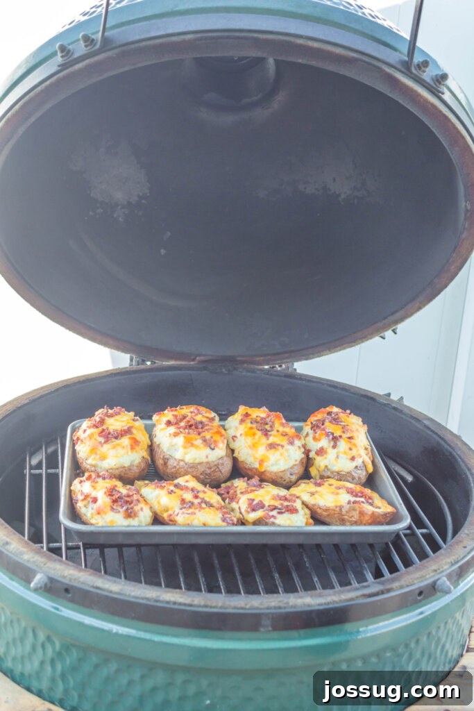Smoky Grilled Twice-Baked Potatoes 3 Grilled twice baked potatoes on a hot grill, showcasing the smoky preparation process and grill marks.