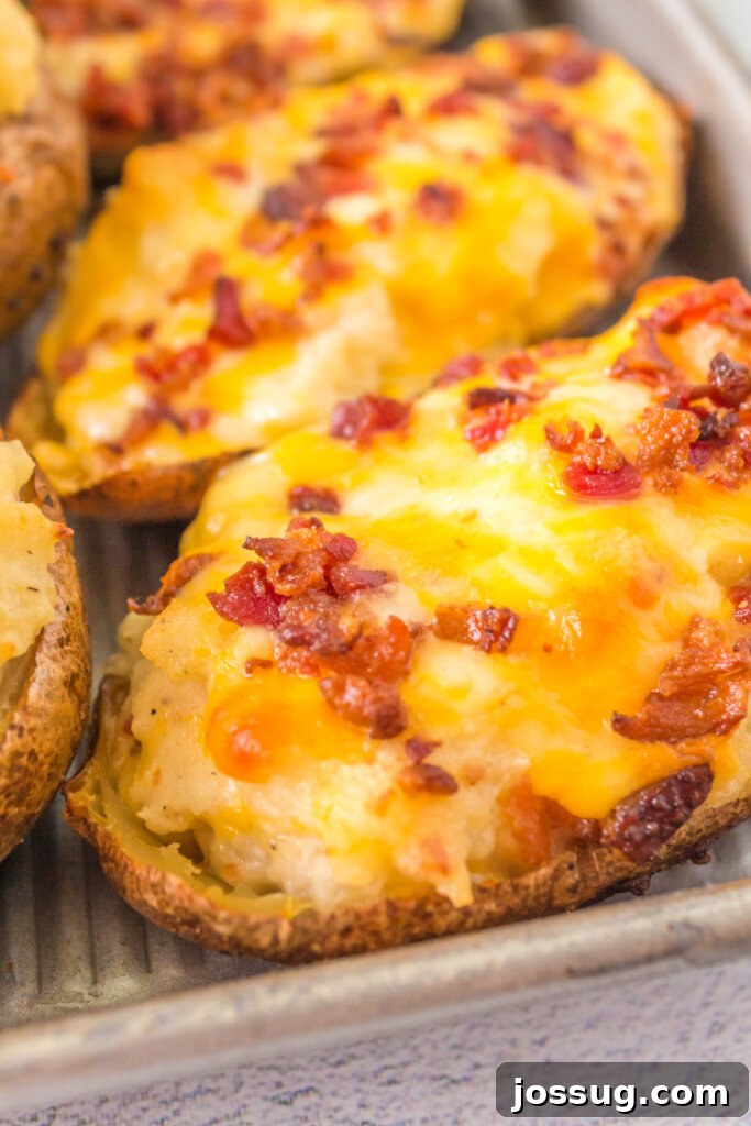 Smoky Grilled Twice-Baked Potatoes 4 Grilled twice baked potatoes with creamy, cheesy filling on a baking sheet, ready for the second grill session.
