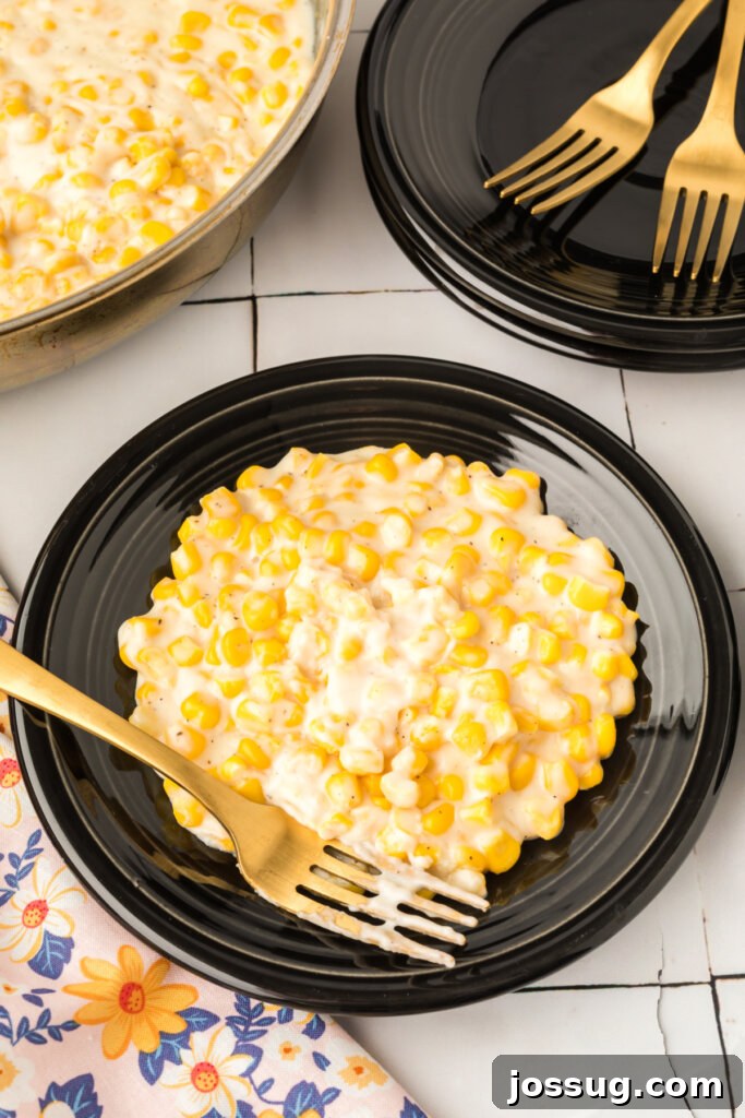 creamed corn on black plate with fork