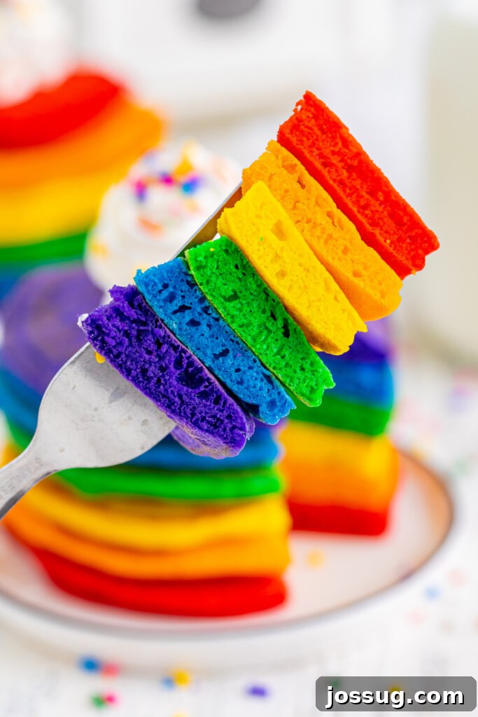 bite of rainbow pancakes with allof the colors on the fork