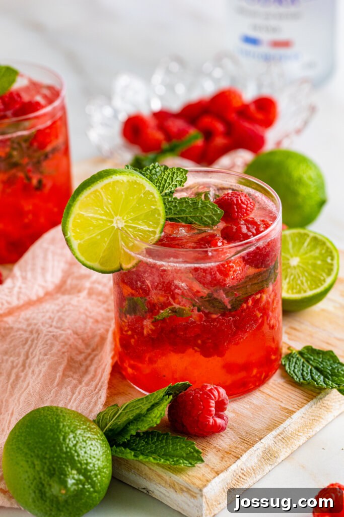 A single Berry Vodka Smash cocktail sitting on a wooden table outdoors, bathed in natural light.
