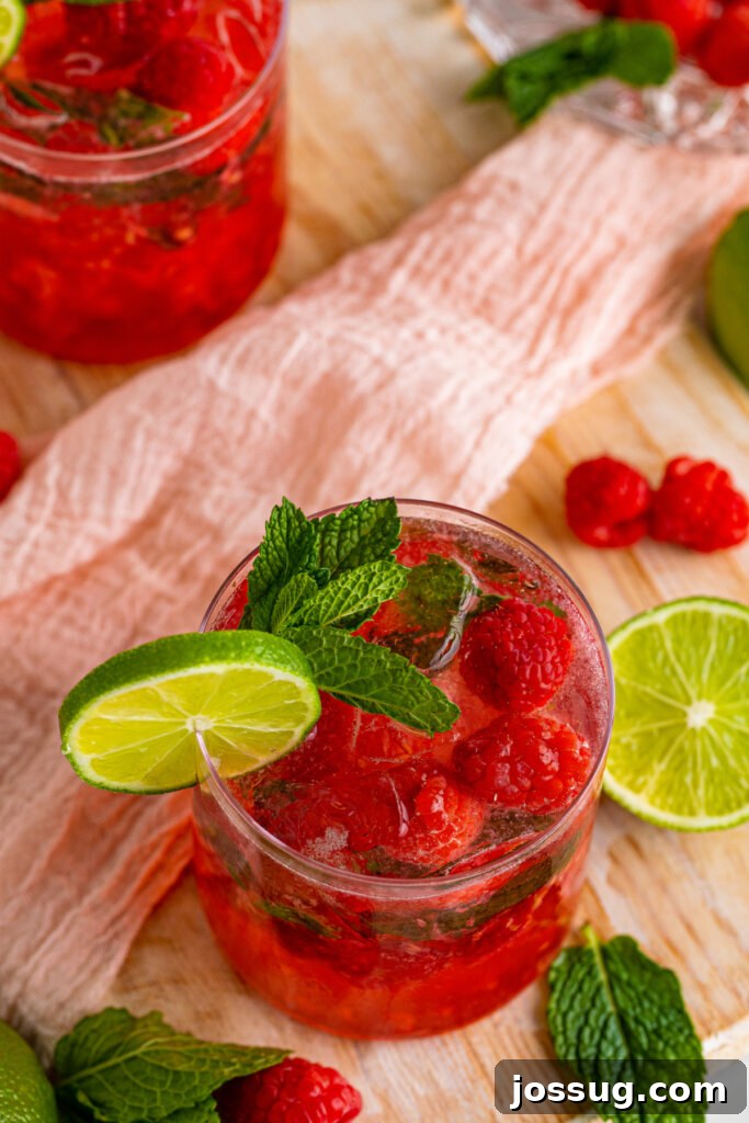 Looking down into a single Berry Vodka Smash, showcasing the muddled berries and mint at the bottom.