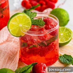 Closeup of a berry vodka smash cocktail, showing the ice and fruit.