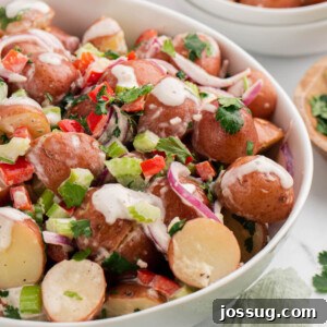 Closeup of Red Potato Salad in a white bowl, garnished