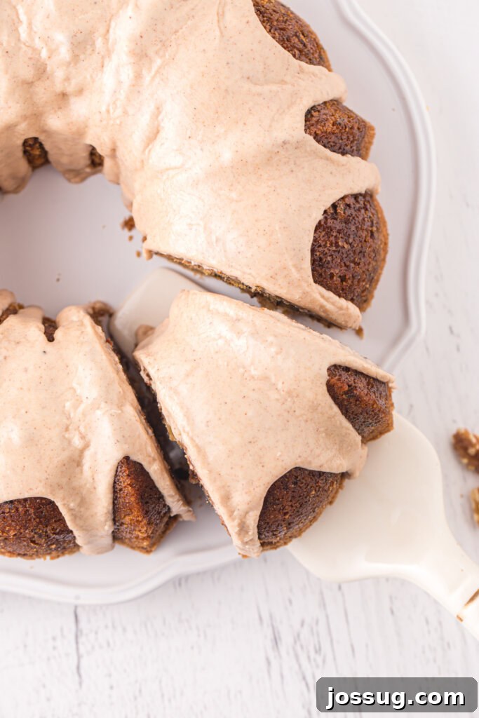 Garden Green Bundt Delight 5 A spatula carefully lifting a moist slice of Zucchini Bundt Cake from the full cake, revealing its tender crumb.