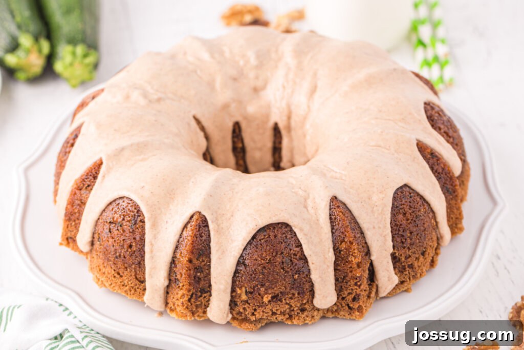 Garden Green Bundt Delight 6 Close-up of a delightful Zucchini Bundt Cake adorned with a sweet cinnamon icing, resting on a rustic serving plate.