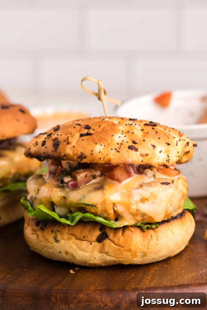 Explosive Bang-Bang Chicken Burgers 2 Finished gourmet chicken burger with bang-bang sauce on a wooden board, ready to be enjoyed.