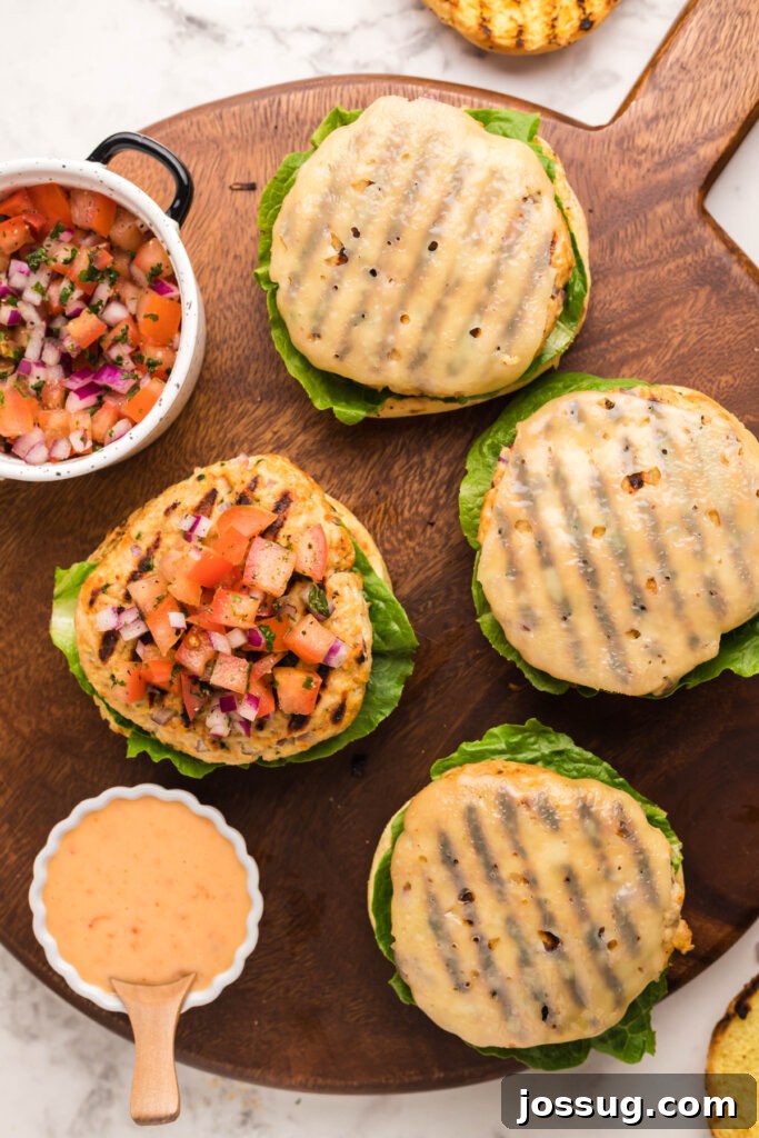 Explosive Bang-Bang Chicken Burgers 5 Ingredients for gourmet chicken burgers laid out for assembly, featuring fresh vegetables, a chicken patty, and cheese.