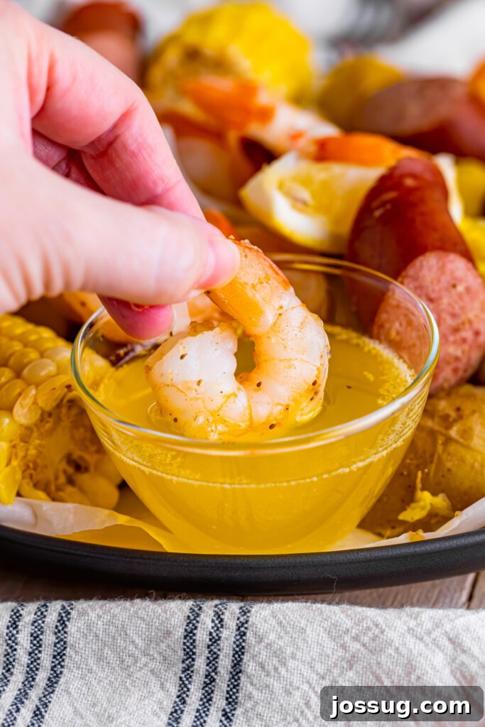 hand dipping shrimp in butter