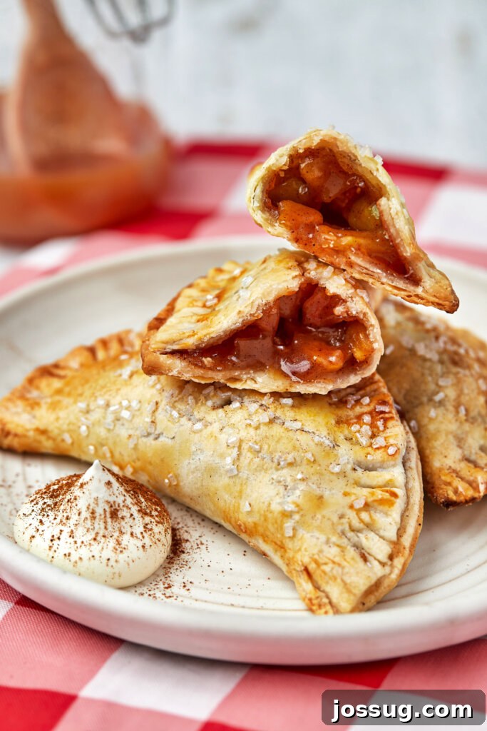 Golden Air Fryer Apple Hand Pies 3 air fryer apple hand pies on plate with the top one opened to show the inside