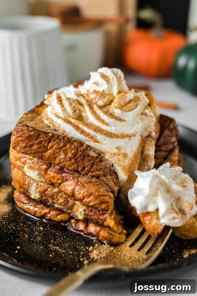 Delicious pumpkin spice French toast on a plate with a fork taking a bite, showcasing the golden-brown crust and soft interior.