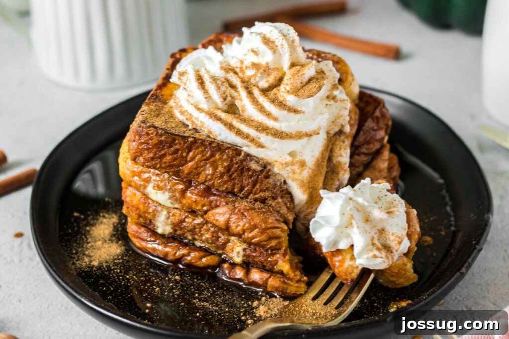 Two slices of pumpkin spice French toast on a black plate, artfully arranged and ready to be enjoyed.