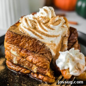 Closeup of pumpkin spice french toast ready to eat, served with whipped cream and syrup.