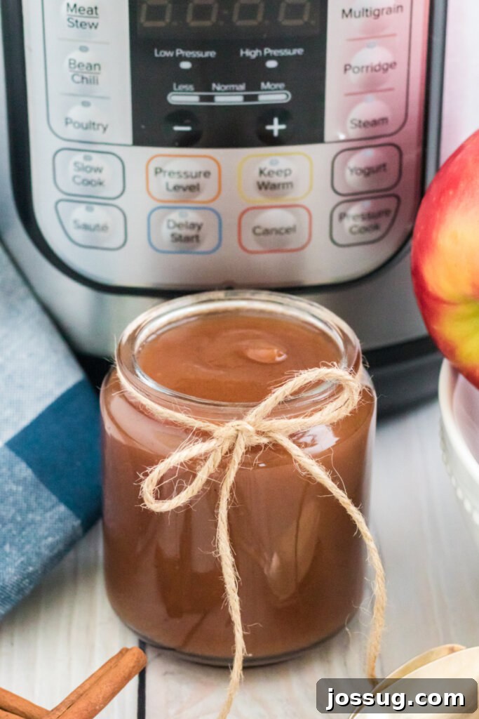 jar of homemade apple butter in front of an instant pot