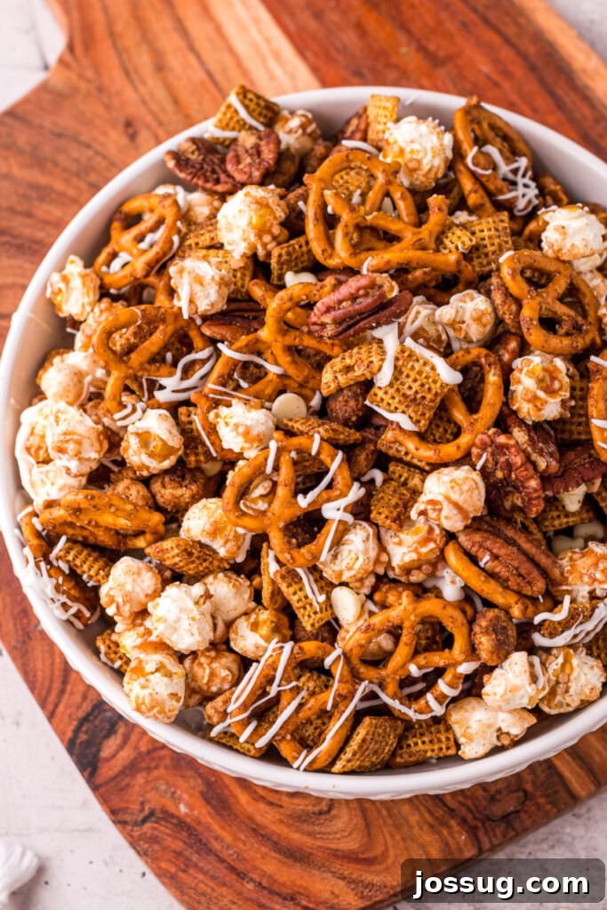 Crispy Autumn Air Fryer Snack Mix 2 A bowl overflowing with golden, spiced Air Fryer Fall Chex Mix, featuring visible rice cereal, caramel popcorn, and pecans, evoking warmth and autumn flavors.