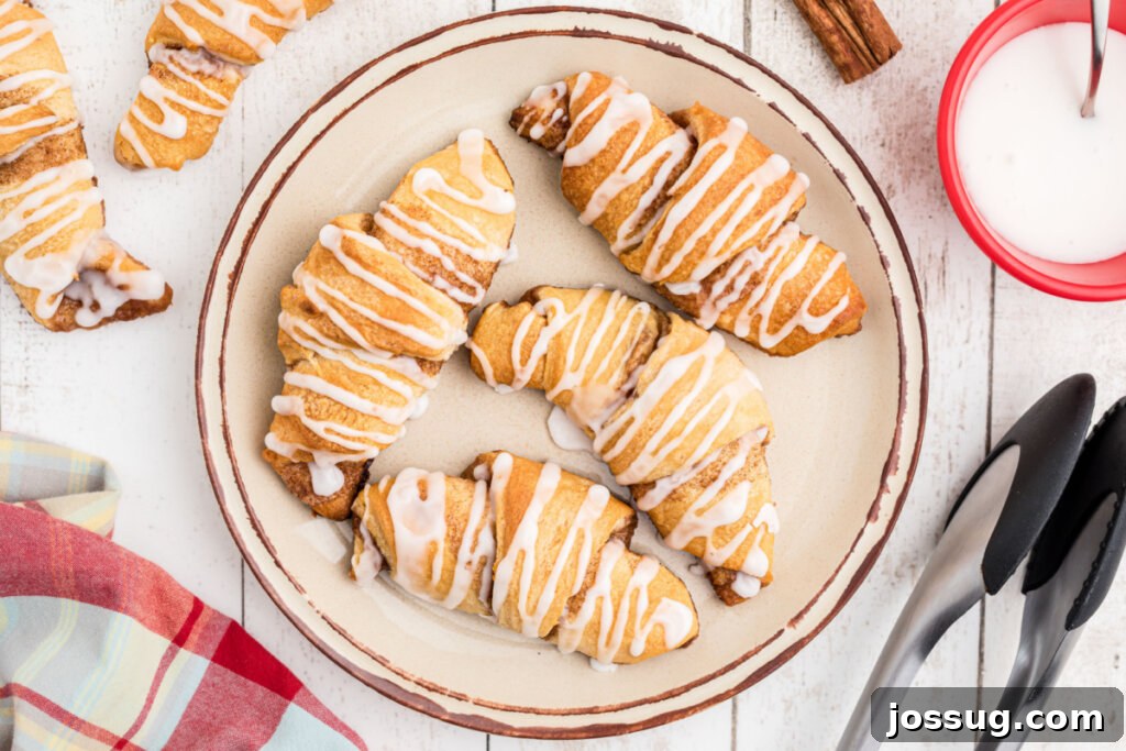 Sweet Cinnamon Crescents 6 four cinnamon crescent rolls on a white plate, glistening with glaze