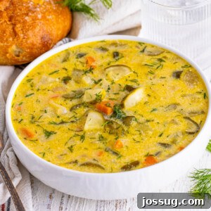 A delicious bowl of creamy Dill Pickle Soup garnished with fresh dill.