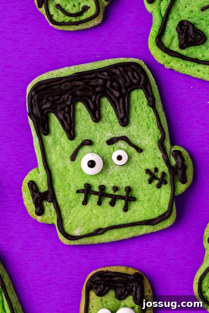 Stitched-Up Monster Cookies 5 Close-up of a single decorated Frankenstein cookie on a purple background, highlighting its details.