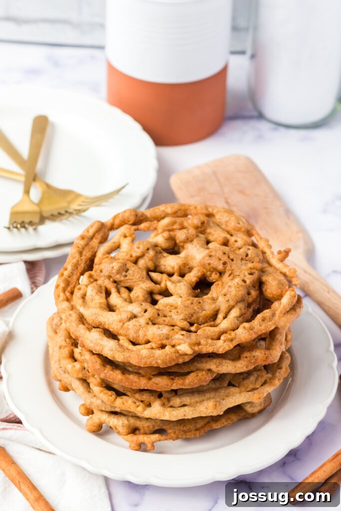Autumn Spice Swirl Cakes 3 A delightful stack of Pumpkin Spice Funnel Cakes, invitingly arranged on a plate.