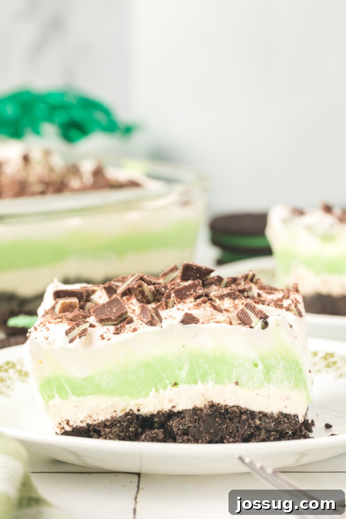 Layers of Luxe: Grasshopper Lasagna 2 A perfectly portioned slice of Grasshopper Lasagna Lush on a white plate, showcasing its distinct green and brown layers.