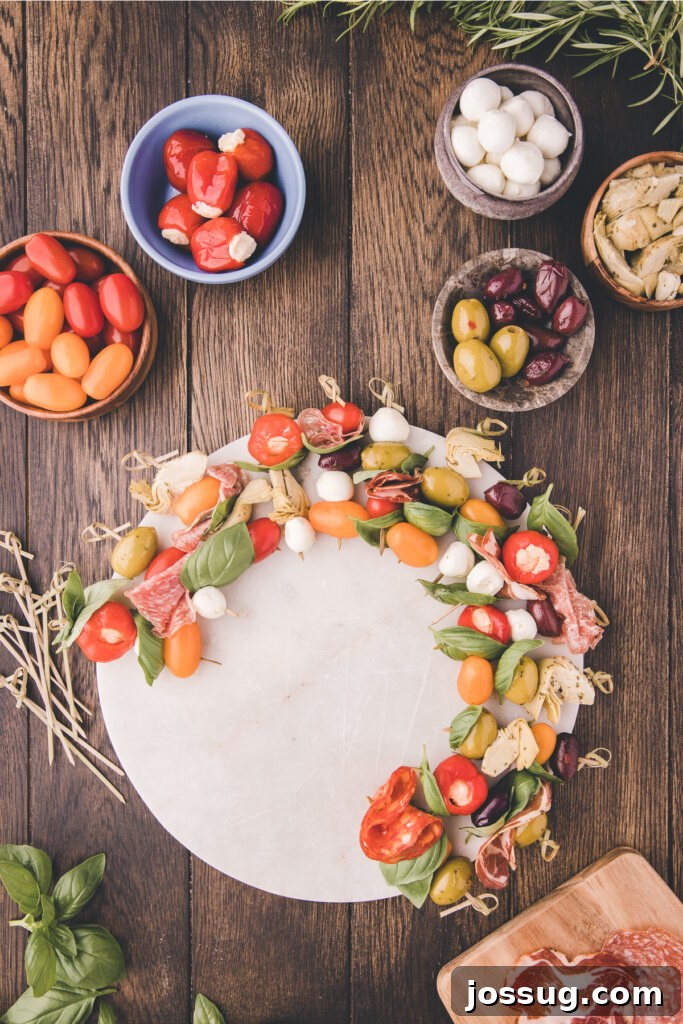 Gourmet Grazing Wreath 5 Numerous antipasto skewers, each generously loaded with a mix of meats, cheeses, and vegetables, are elegantly arranged in a perfectly circular pattern on a large serving platter, forming the initial structure of a festive wreath.