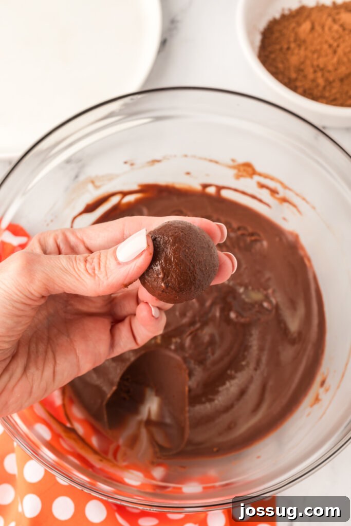 Hands rolling chocolate ganache into small truffle balls