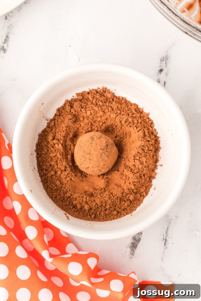 Chocolate truffle balls being rolled in cocoa powder