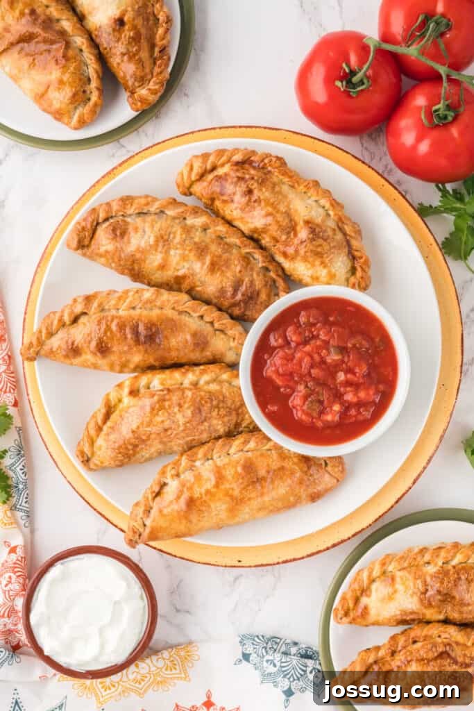 Crispy Air-Fried Beef Empanadas 4 Five golden-brown beef empanadas arranged on a plate with a side of fresh salsa