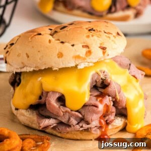 Closeup of a delicious homemade Beef and Cheddar sandwich, showing the tender beef and melted cheese sauce.