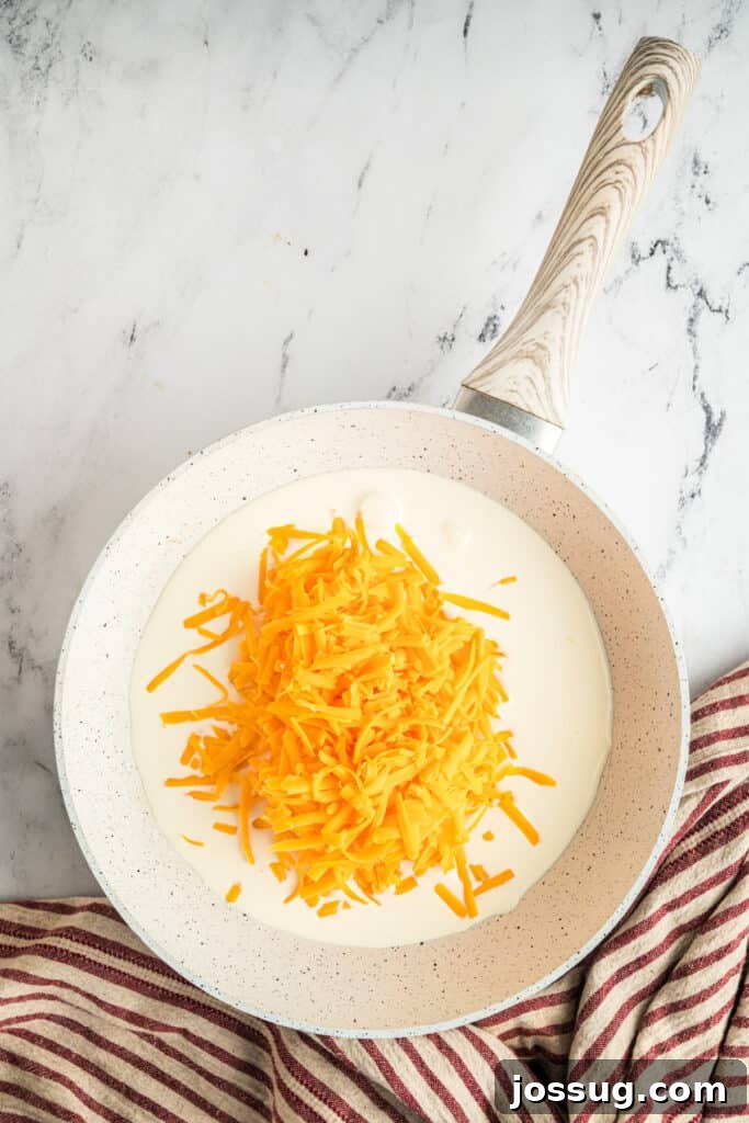 In a non-stick skillet, add the heavy cream and shredded cheddar cheese, ready to be heated.