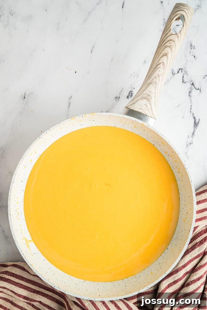 The non-stick skillet covered with a lid, with the smooth cheese sauce inside, set aside to keep warm.