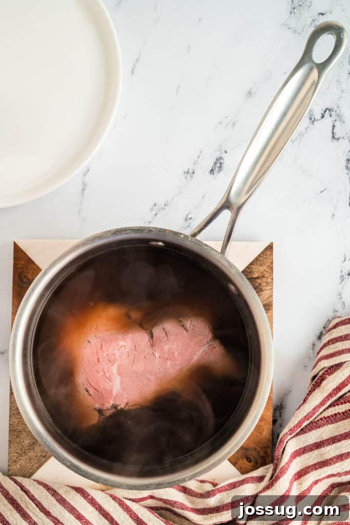 Warming beef stock in a 2-quart saucepot on the stovetop.