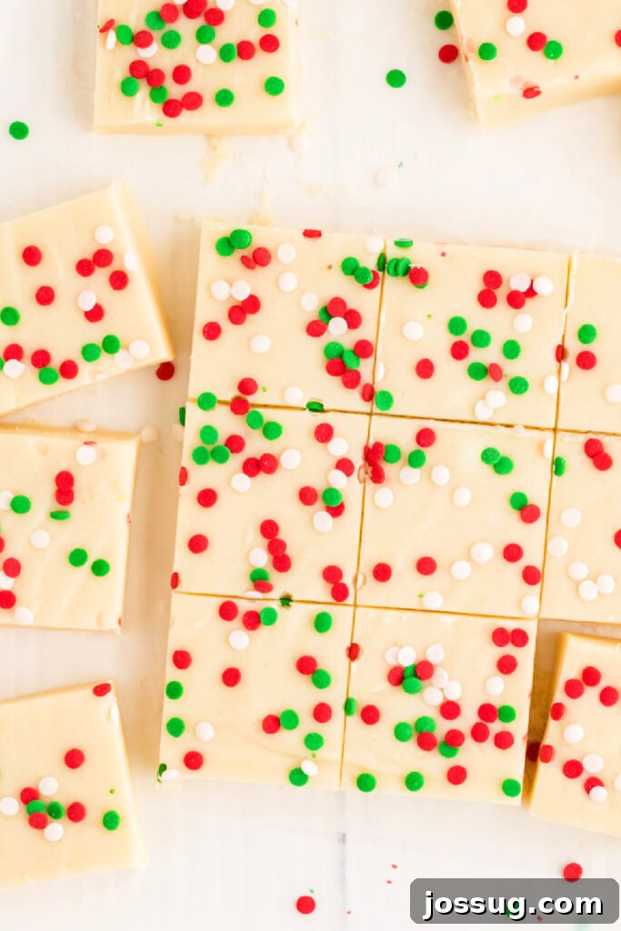 Frosted Sugar Cookie Fudge 5 A large slab of freshly made sugar cookie fudge, beautifully cut into uniform squares, adorned with festive sprinkles