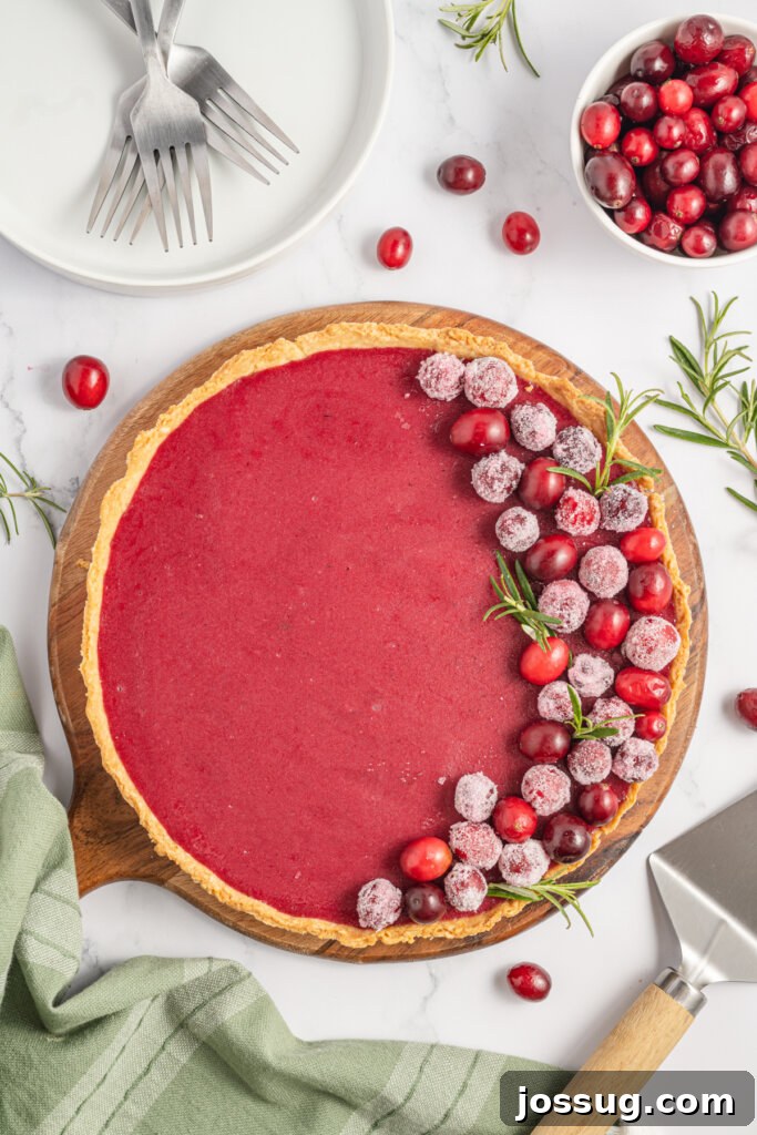 looking down onto a whole unsliced cranberry curd tart, vibrant red